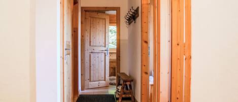Un couloir en bois avec une porte donnant sur une pièce.