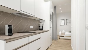 Cozinha moderna com armários brancos, painel de backsplash de mármore e coifa embutida.