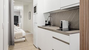 A modern kitchen with white cabinets, a black countertop, and a built-in stove.