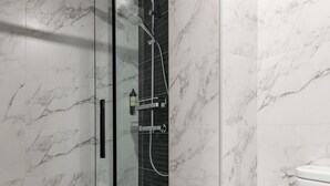 A modern bathroom with a glass shower enclosure, marble tiles, and a toilet. - Charming Madrid Castilla I - Studio for 4 people (Madrid)
