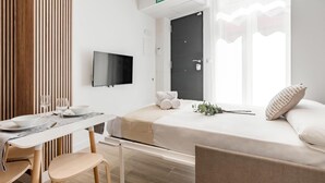 A modern hotel room with a bed, a desk, and a TV. - Charming Madrid Castilla I - Studio for 4 people (Madrid)
