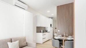 A modern living room with a sofa and a dining area with a table and chairs. - Charming Madrid Castilla II - Studio for 4 people (Madrid)