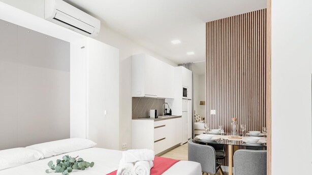 A modern hotel room with a bed, a dining area, and a kitchen. - Charming Madrid Castilla II - Studio for 4 people (Madrid)