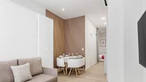 Un salon moderne avec un canapé, une table à manger et des chaises, ainsi qu’un mur d’accent en bois.