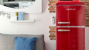 A red refrigerator, a grey sofa with a blue pillow, and a brick wall. - Madrid Villaverde VI - Apartament with patio, AC (Madrid)