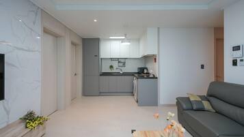 Un apartamento moderno con cocina, sala de estar y un sofá.