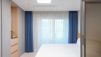 Una habitación de hotel moderna con cama, escritorio y armario.