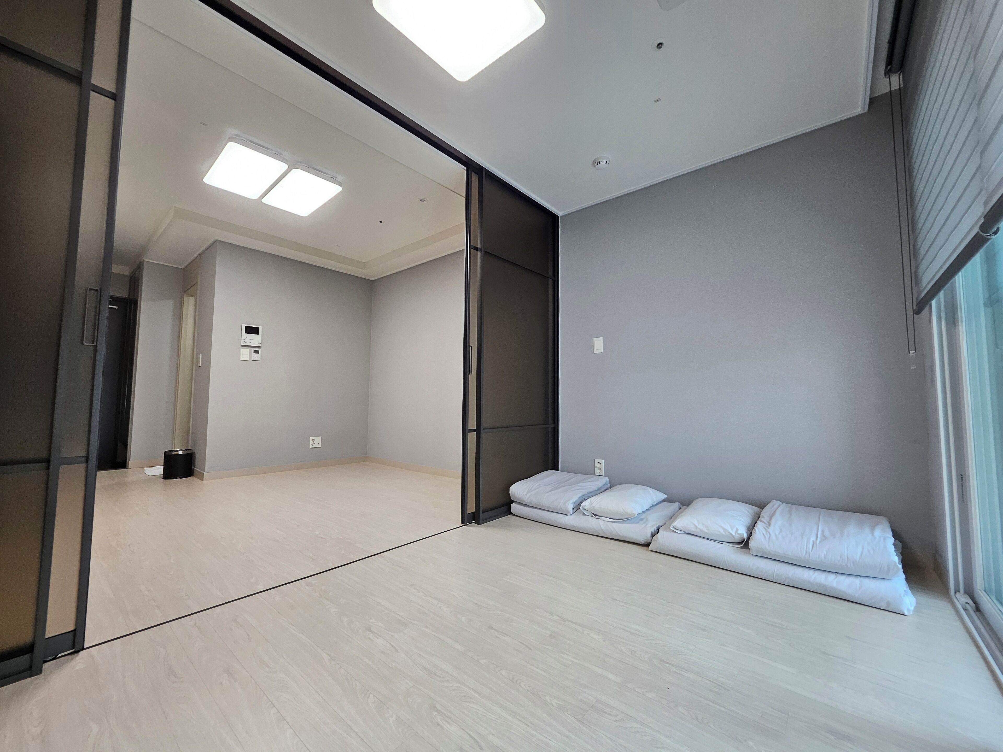 Una habitación de hotel moderna con una cama grande, un rincón de descanso y vistas al exterior.