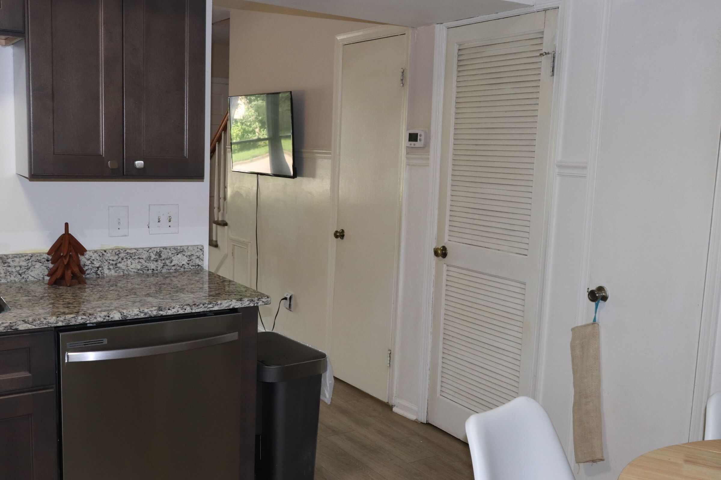 A kitchen with a built-in dishwasher, a microwave, and a TV mounted above the counter.