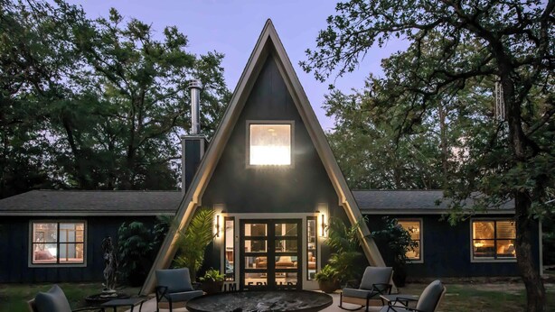 A triangular-shaped building with a central courtyard, outdoor seating, and a fire pit.