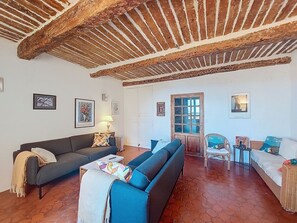 A living room with a sofa, a coffee table, a lamp, and a door.