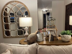 A living room with a large mirror, a lamp, a decorative chair, and a potted plant. - The Lazy Cow Inn  Sleeps 9+ (Hutchinson)