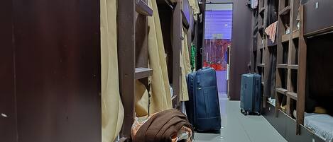 A narrow corridor with luggage and storage shelves.