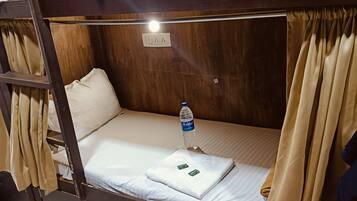 A bunk bed with a water bottle and a towel on the mattress.