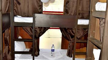 A bunk bed room with a window, curtains, and balloons.