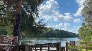 A river with signs indicating canoe and kayak launch, no swimming, and no personal tubes, rafts, or inflatable flotation devices allowed. - 9-Guest+River Access+Dogs+powerisOn! (Dunnellon)