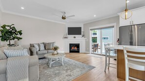 A modern living room with a fireplace, a dining area, and a kitchen with a stainless steel refrigerator. - Professionally Managed | 1 Block to Beach (Seaside Park)