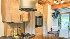 Una cocina moderna con armarios de madera, electrodomésticos de acero inoxidable y una encimera de vidrio.