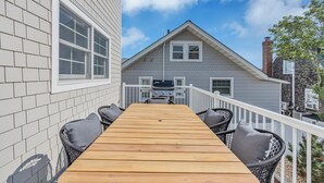 A wooden deck with a table and chairs, leading to a house with a white exterior and a chimney. - Prof Cleaned | Pup Friendly | Linen+Towel | Coffee (Seaside Park)