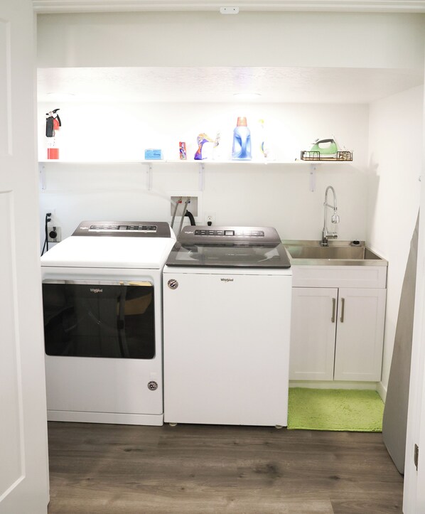 A compact kitchen with a Whirlpool washer and dryer, a sink, and a green rug. - Provo 3-bedroom; new, fireplace, BBQ, AC, fast WiFi. Close to BYU, MTC, Sundance (Provo)