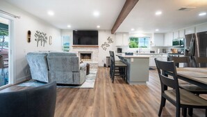 Una cocina moderna con una isla central, electrodomésticos integrados y una chimenea de piedra.
