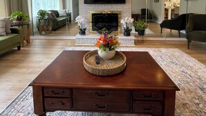 A modern living room with a wooden coffee table, a fireplace, and a ceiling fan. - Apartment in Perry Hall area (Nottingham)