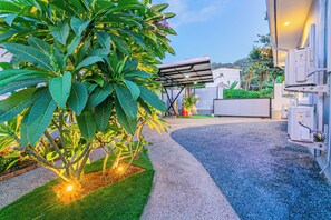 Enjoy the serene atmosphere of this beautifully maintained outdoor space, surrounded by lush greenery and a modern building.