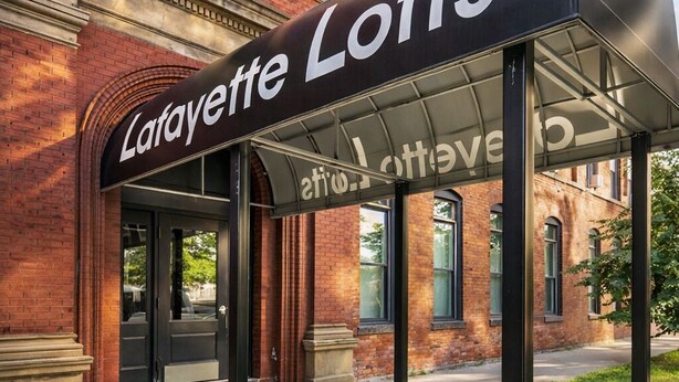 Une entrée couverte menant aux appartements Lafayette Lofts, avec un bâtiment en briques en arrière-plan.