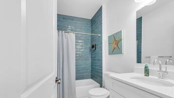 A bathroom with a bathtub, toilet, and sink.