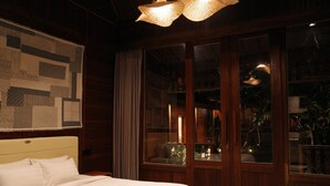 A bedroom with a large bed, wooden wardrobe, and a window with curtains. - The Riang Villa (Kerobokan)
