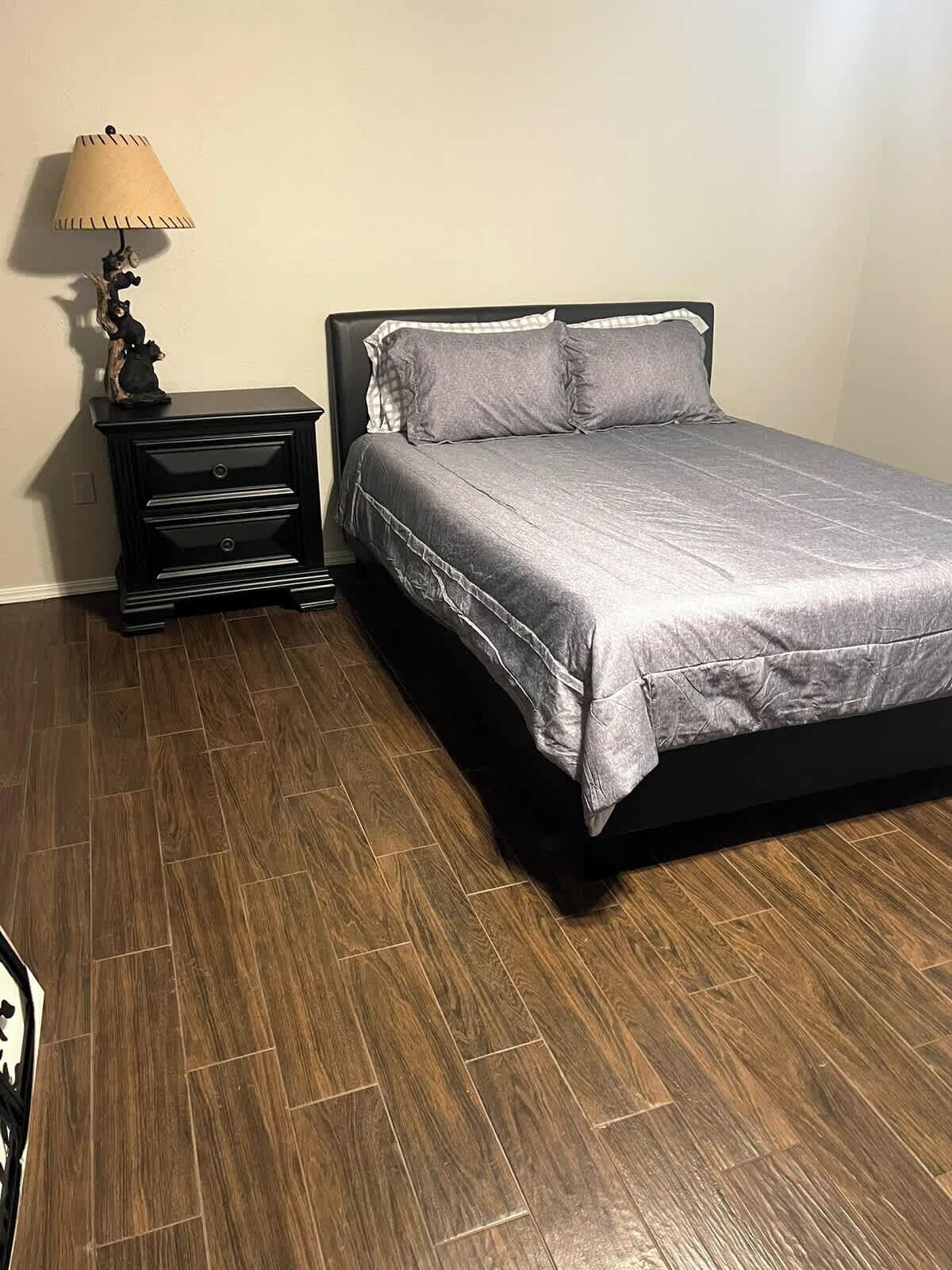 Ein Schlafzimmer mit einem Bett, einem Nachttisch und einer Lampe.