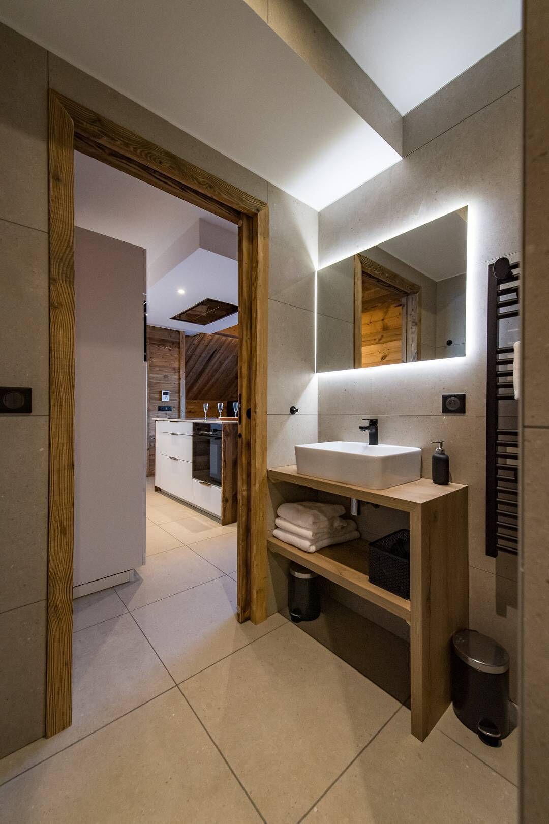 Un bagno moderno con uno specchio grande, un lavandino e un porta asciugamani.
