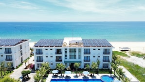 A hotel with a pool, solar panels, and a view of the ocean. - Hoang Yen Boutique Hotel (Da Nang)