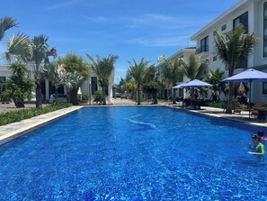 Een buitenzwembad en ligstoelen