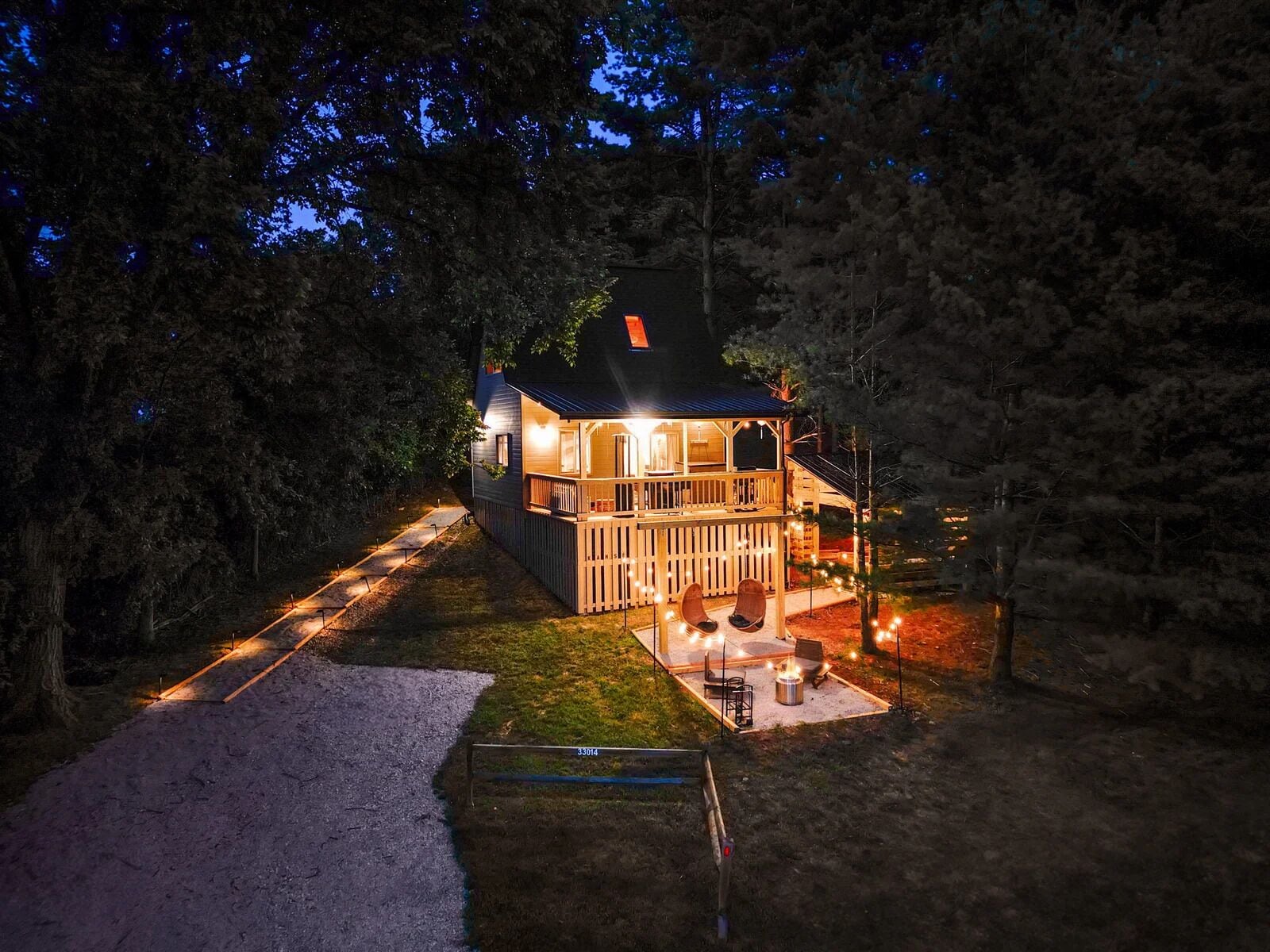 A house with a porch, a deck, and a fire pit area.
