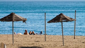 A beach with two thatched umbrellas and a sandy shore. - Solaga - Martinez Virel (Málaga)