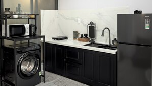 Een moderne keuken met een inbouw wasmachine, een koelkast en een magnetron.