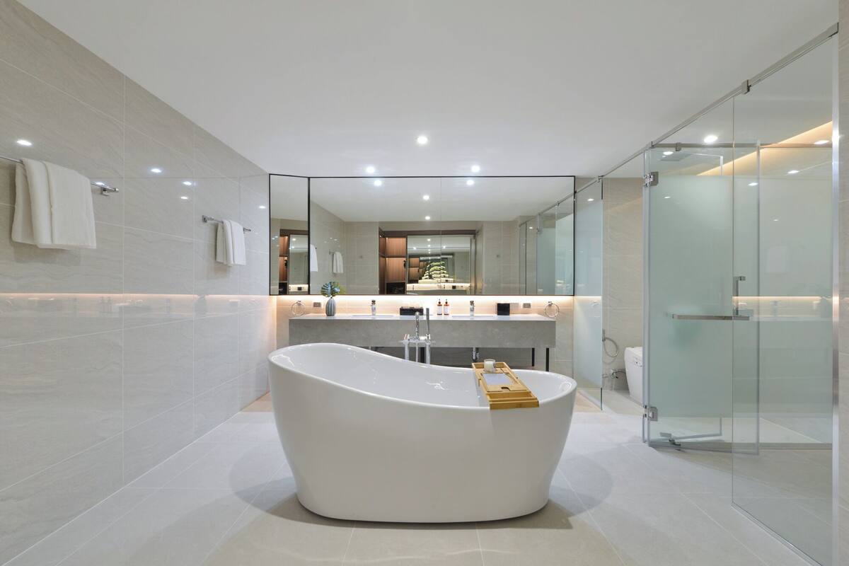 Une salle de bain moderne avec une baignoire sur pieds, une douche à parois de verre et un meuble-lavabo avec un miroir.