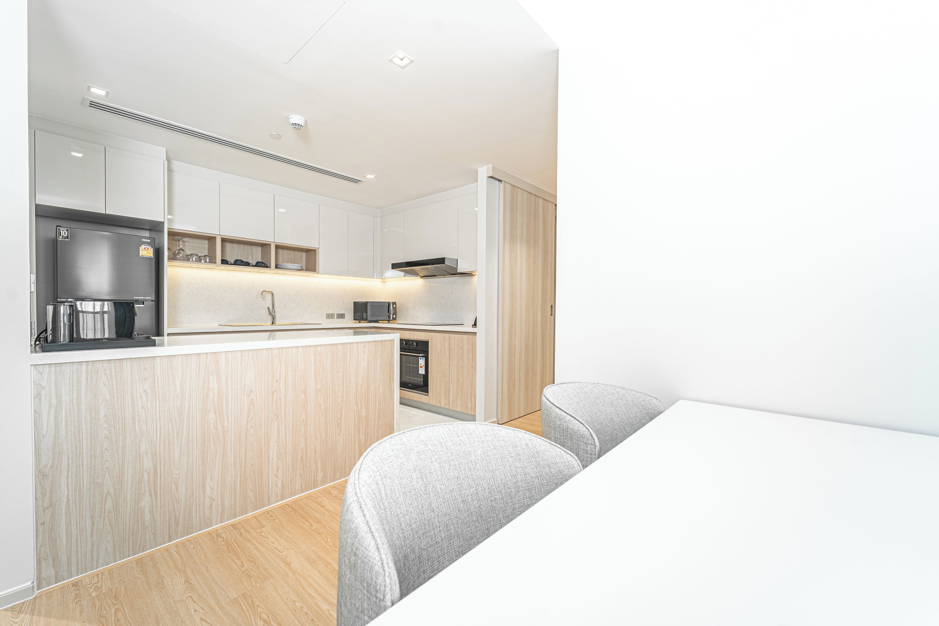 A modern kitchen with a central island, built-in appliances, and a minimalist design.