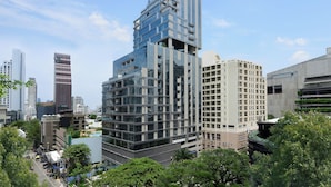 Een modern hoog gebouw met meerdere balkons en een glazen gevel.