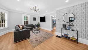 A modern living room with a grey sofa, a round coffee table, and a patterned rug.