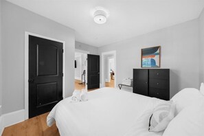 A hotel room with a bed, a wardrobe, a desk, and a painting on the wall. - Spacious 3BR Near ATL Airport|Flight Crew Friendly (Atlanta)