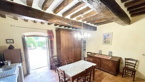 A rustic dining area with a wooden table and chairs, a chandelier, and a large wooden cabinet. - Secluded Umbrian Villa with Private Pool, Perfect for Nature Lovers (Terzo la Pieve Basso)