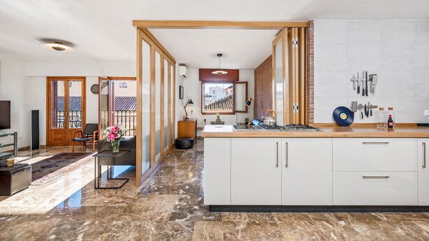 A modern kitchen with a marble floor, wooden accents, and a large island. - Solaga - Mary (Málaga)
