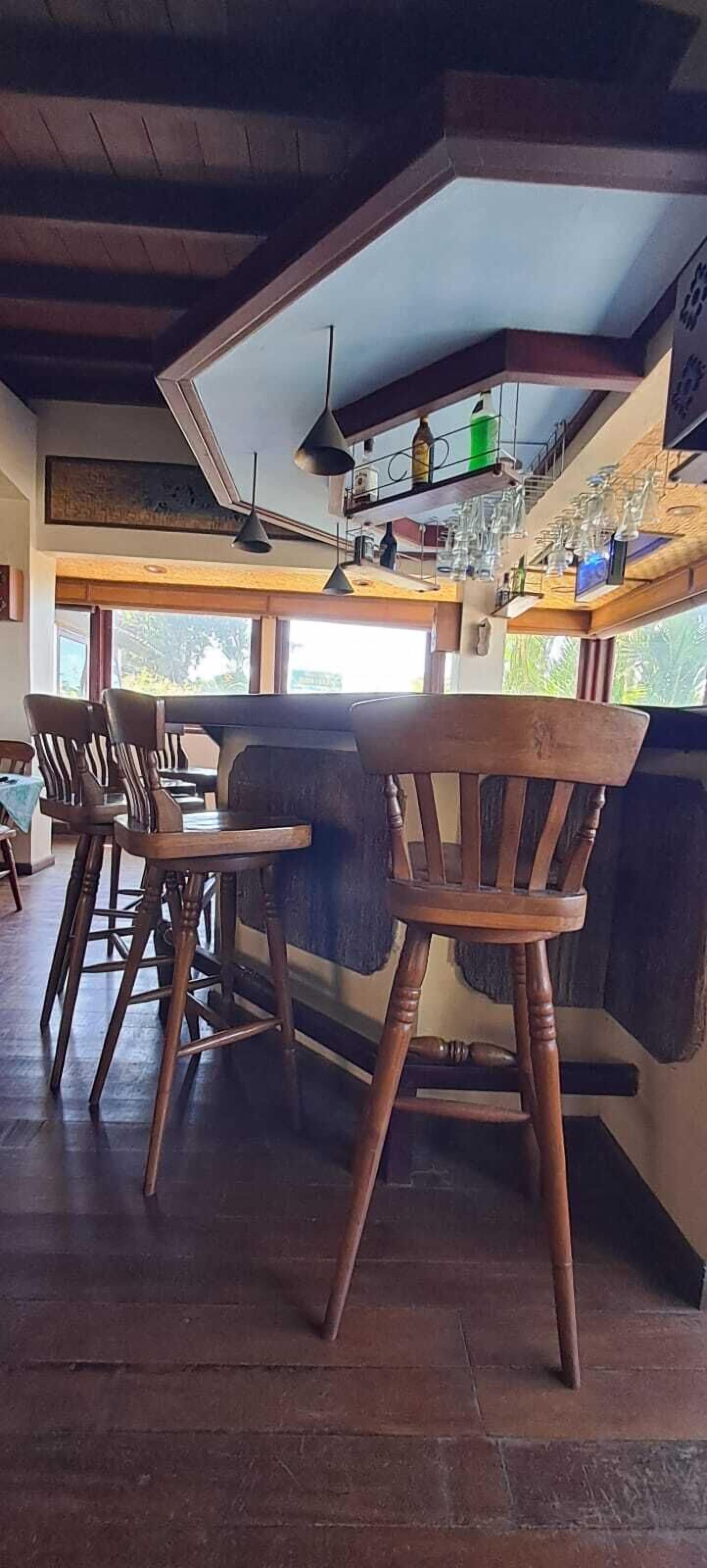 A bar area with wooden chairs and a bar counter.