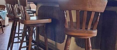 A bar area with wooden chairs and a bar counter.