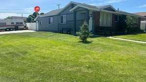 A single-story house with a front porch, a small front yard, and a red balloon. - Confortable Tiny Home in  Magna (Magna)