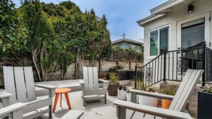 A patio area with outdoor furniture, including chairs and tables, and potted plants. - Zen Point Loma Garden House (San Diego)