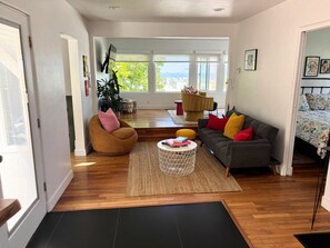 Uma sala de estar ampla com sofá, poltrona e mesa de centro.