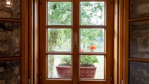 A rustic stone interior with a wooden-framed window overlooking a garden. - Gorenja Trebuša, Domačija Gačnik (Tolmin)